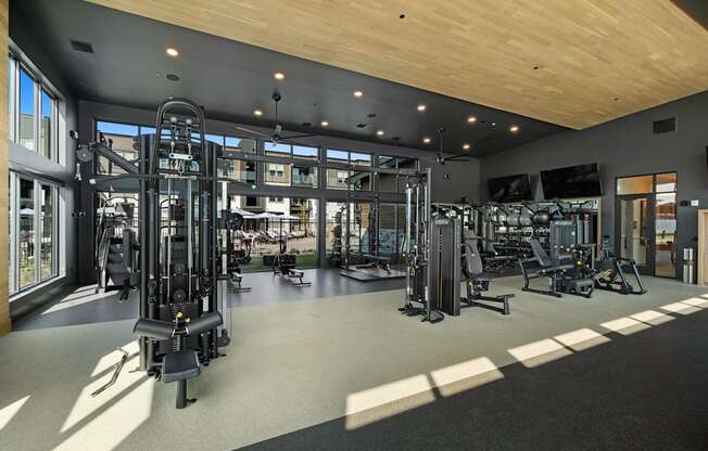 a gym with a lot of exercise equipment and windows