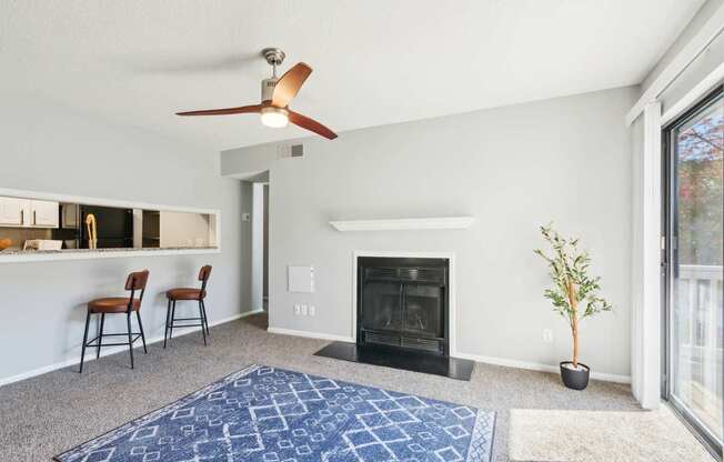 A living room with a fireplace and a ceiling fan.