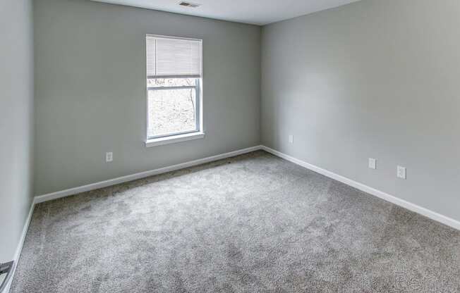 an empty room with carpet and a window