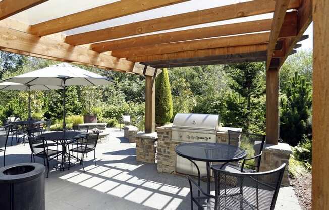 a patio with tables and chairs and a grill