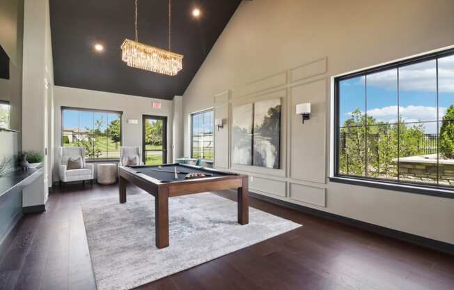 a game room with a pool table and large windows at The Depot in The Depot Raymore, MO 64083