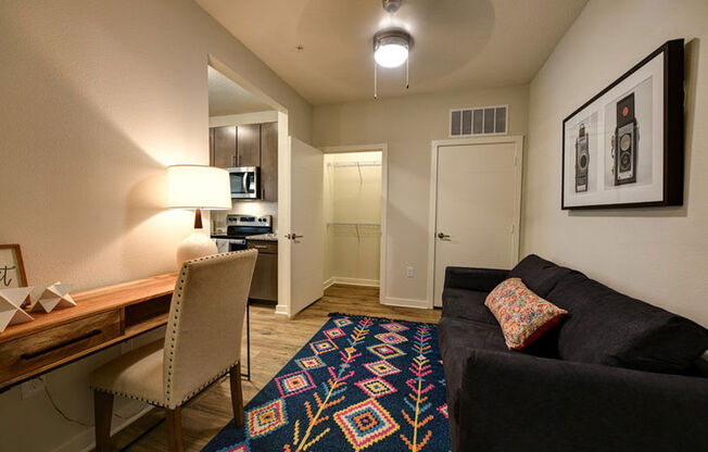 a living room with a couch and chair in front of a desk with a lamp and a  at Fusion, Jacksonville, Florida