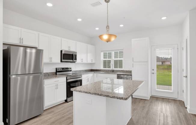 a renovated kitchen with white cabinets and granite counter tops