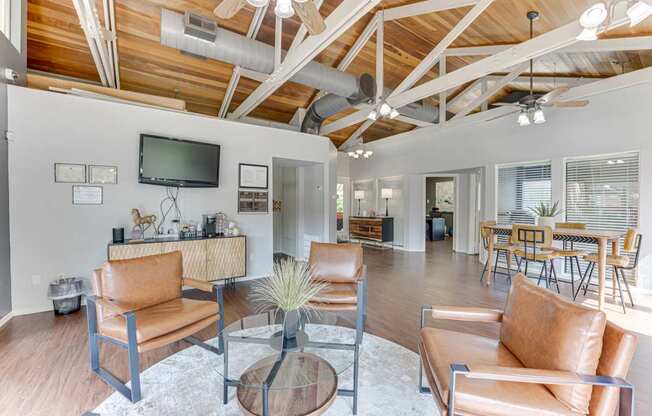 A living room with a brown leather couch and a glass coffee table at Copper Hill Apartments, Bedford, TX