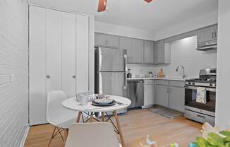 A modern kitchen with a dining table set for two.