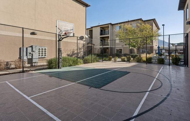 an outdoor basketball court in front of a building