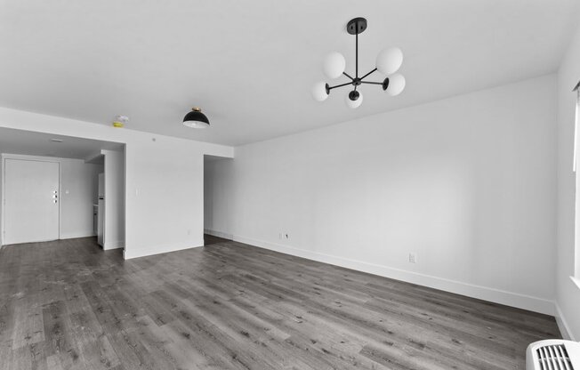 an empty living room with white walls and wood floors