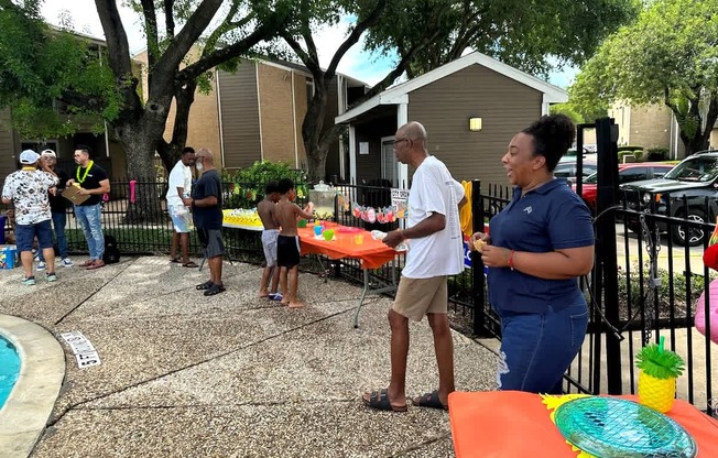 A group of people are gathered around a table with a pineapple design on it.