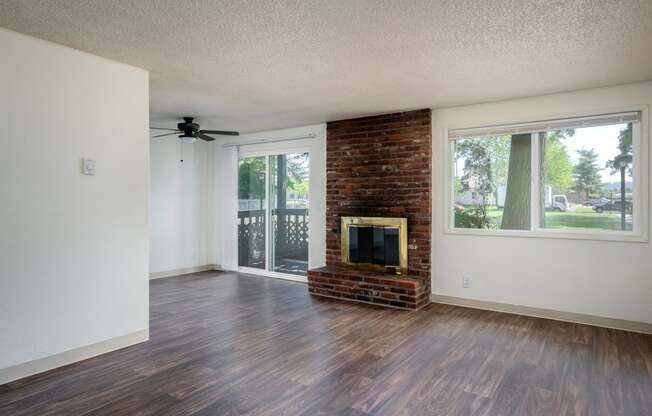 an empty living room with a fireplace and a sliding glass door