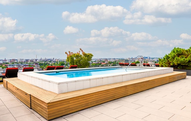 the pool on the rooftop of a building with a city in the background