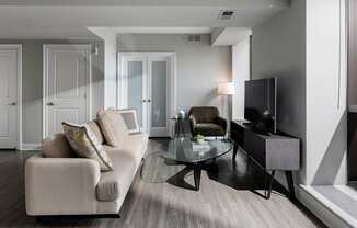 A sun-lit, modern living room showcasing the open-concept design of apartments in Rittenhouse Square Philadelphia PA.