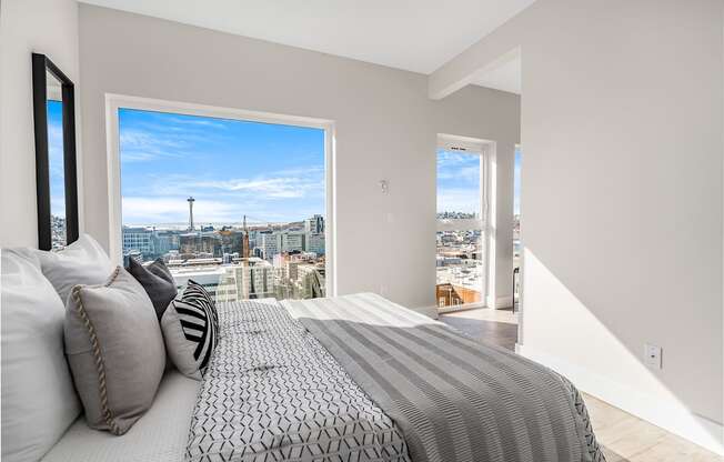 a bedroom with a bed and a view of the city  at Oslo, Seattle, 98102