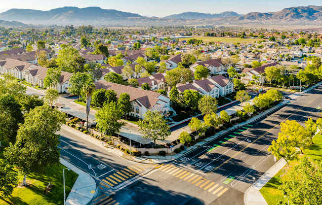 A suburban street with houses on both sides and a mountain range in the distance.