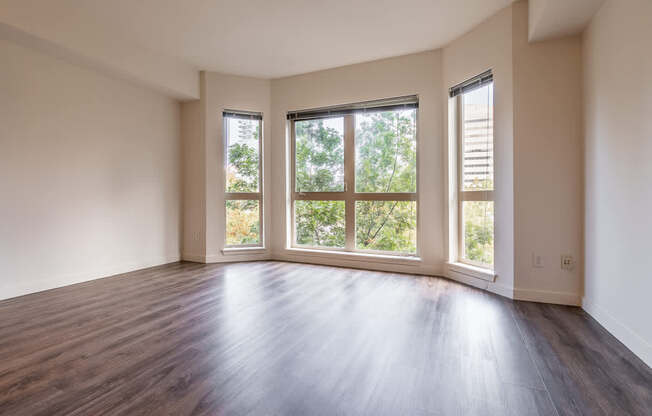 A room with wooden floors and two windows.