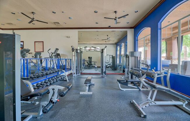 a gym with weights and cardio equipment in a building with windows at Club at Coldwater Springs, Avondale