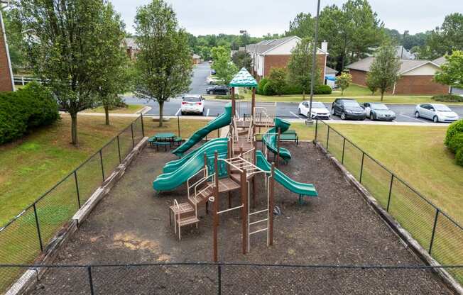 a playground with slides and chairs in a park