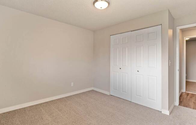A white door is in a room with carpeted floor.