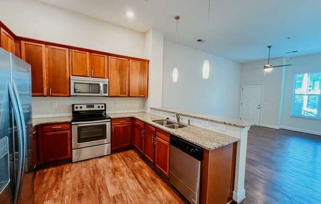 an empty kitchen with wooden cabinets and stainless steel appliances