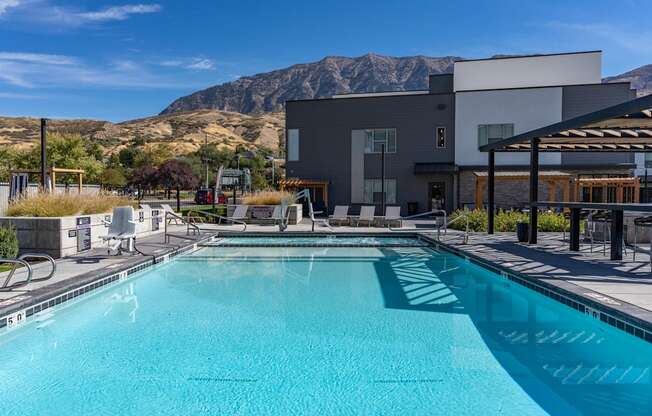 a swimming pool with a building and mountains in the background