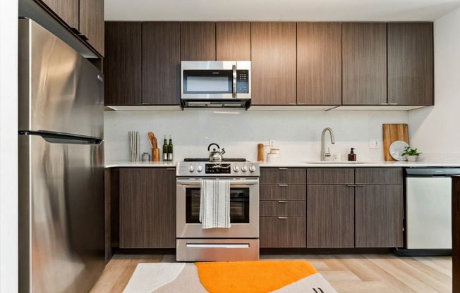 a kitchen with dark wood cabinets and an orange rug at Hydro, Richmond, Virginia