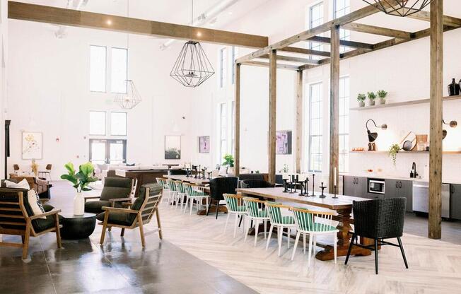 Spacious market-style resident lounge with tables and chairs for residents to relax and converse at The Merchant Apartments, Charleston, SC