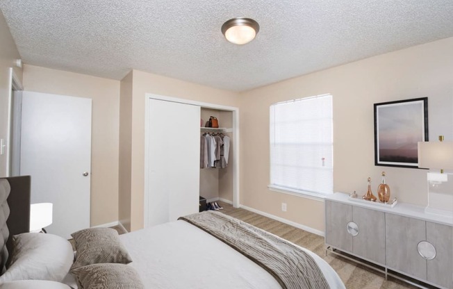 a bedroom with a bed and a dresser and a window