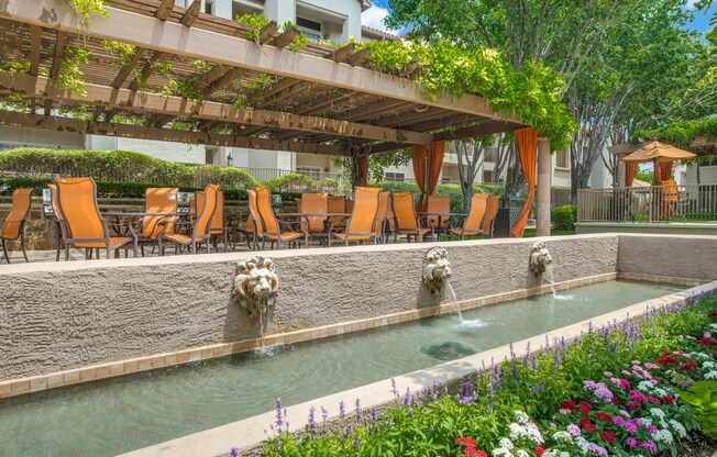 a swimming pool with chairs and water fountains at La Ventura Apartments, Plano, 75093
