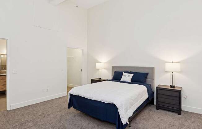 A bedroom with a bed, nightstand, and lamp.