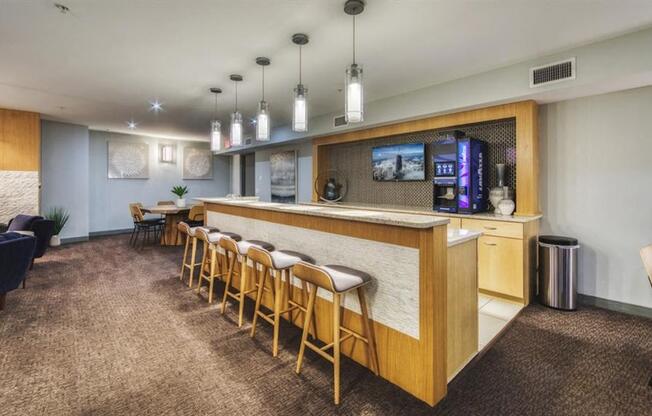 A room with a long wooden bar and several chairs.