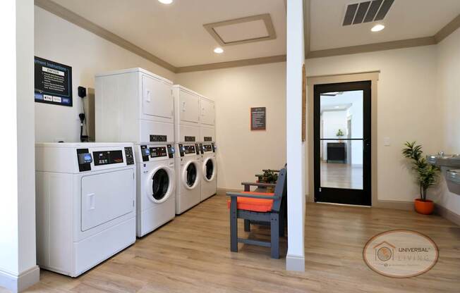 The resident laundry center with washing machines, dryers, and seating.