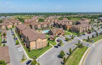 an aerial view of an apartment complex with cars parked in a parking lot