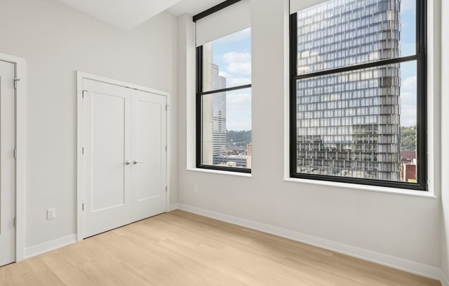 A room with a large window and a view of a cityscape.