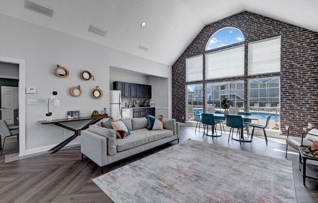 an open living room with a large window and a pool in the background