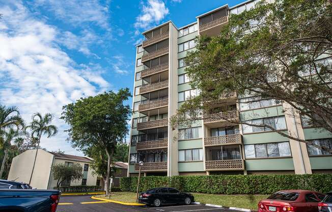 an image of an apartment building with cars parked in a parking lot at Fairways of Inverrary, Lauderhill, FL, 33319