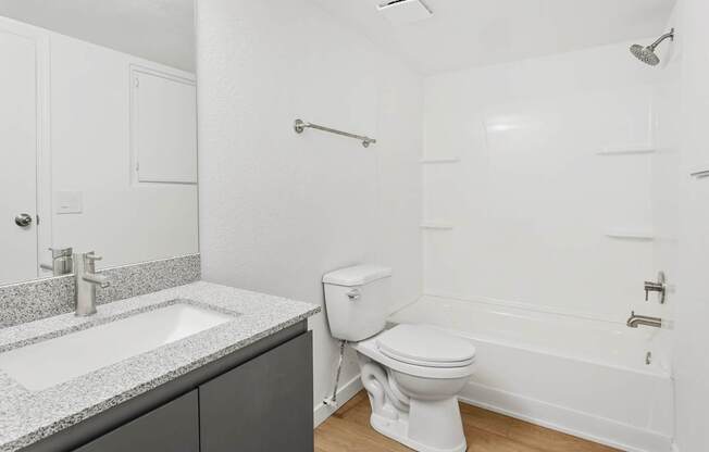 A white toilet sits next to a sink in a bathroom.