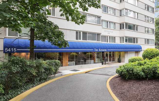 The entrance to The Kenmore apartment building is covered by a blue awning.