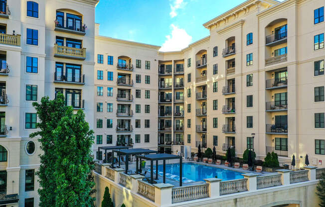 A large, luxurious hotel with a swimming pool in the courtyard.