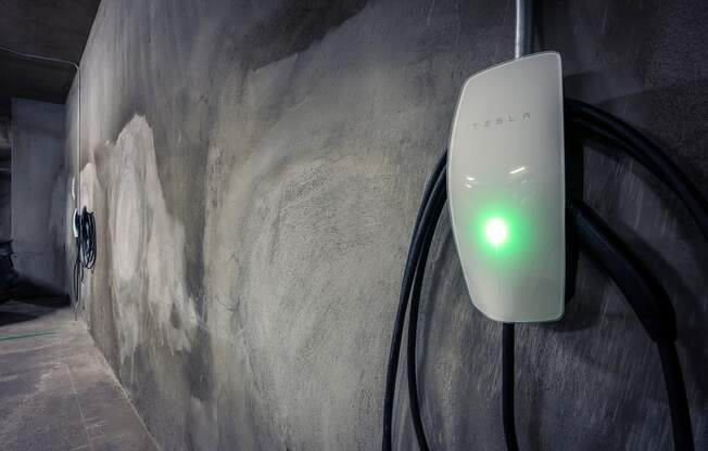 a power adapter plugged into a wall with a green light shining on it