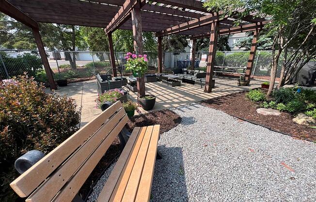 a park with a wooden bench and a pergola