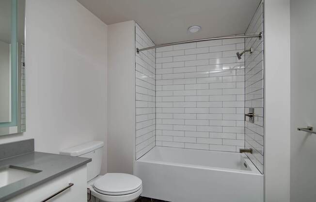 A white bathroom with a toilet, sink, and bathtub.