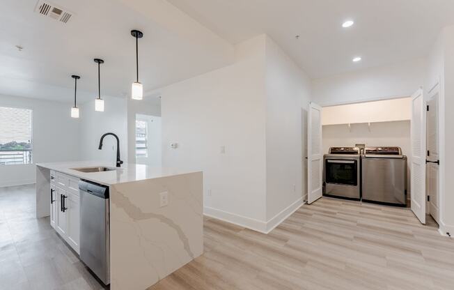 A modern kitchen with a marble island and stainless steel appliances.