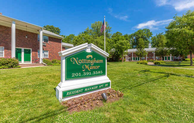 a green and white sign that says northampton manor in front of a brick building at Nottingham Manor Apartments, Montvale, NJ, 07645