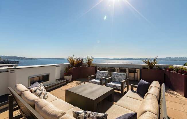 Vela Apartments terrace with a couch and chairs overlooking water