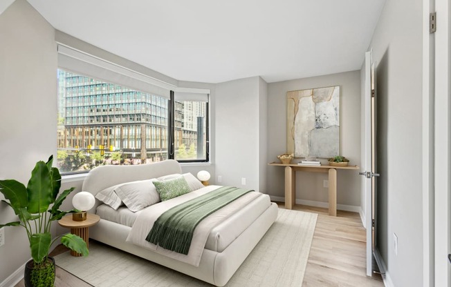 a bedroom with a white bed and a large window