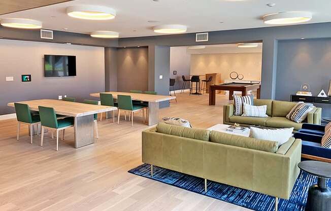 A modern living room with a green couch and a television.