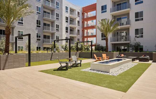 A modern courtyard with a pool and seating area.