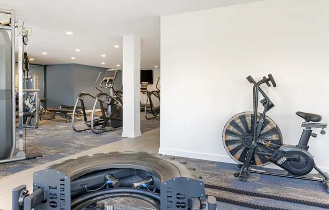 a gym with weights and a wheel in the corner