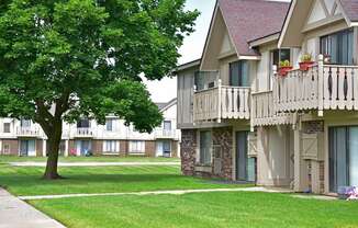 a picture of an apartment complex with a tree in the foreground at Beacon Hill and Great Oaks Apartments, Rockford