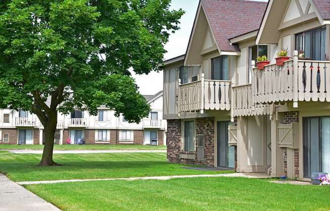 a picture of an apartment complex with a tree in the foreground at Beacon Hill and Great Oaks Apartments, Rockford