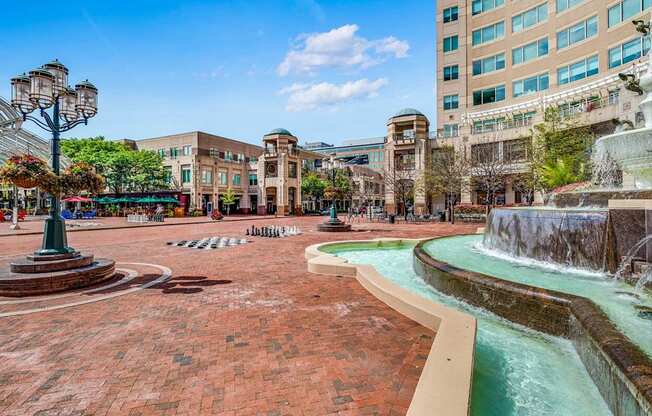 a fountain in a city square with buildings